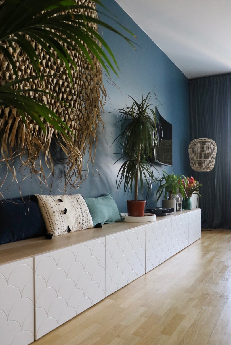 meuble blanc et bois avec plantes et mur bleu derriere